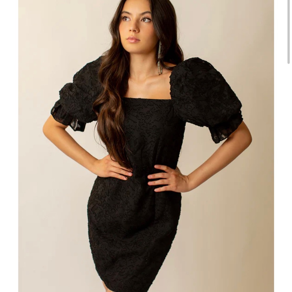 Adorned in lace, this sweet dress with a dramatic puff sleeve